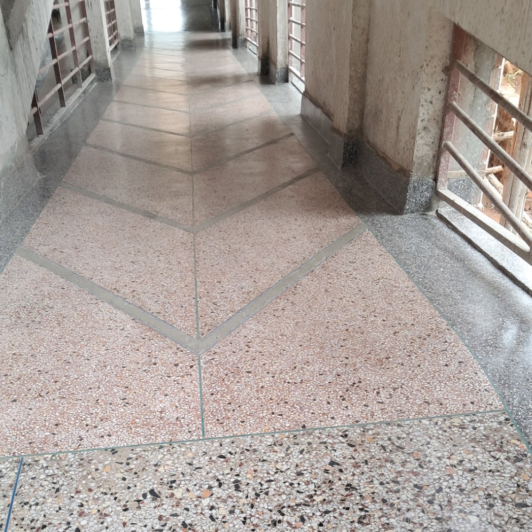 Pink and grey polished terrazzo corridor with geometric borders
